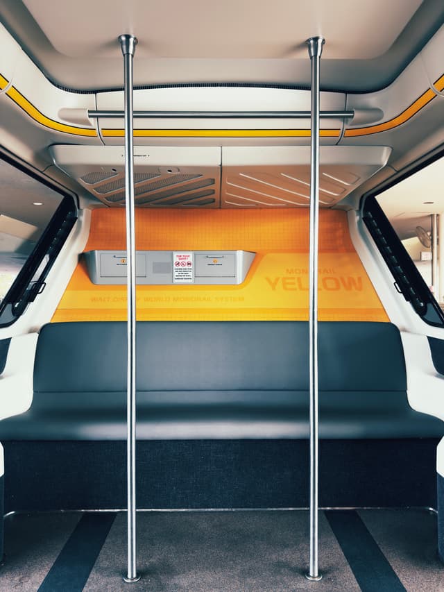 Interior of a public minibus with bench seating and vertical metal handrails